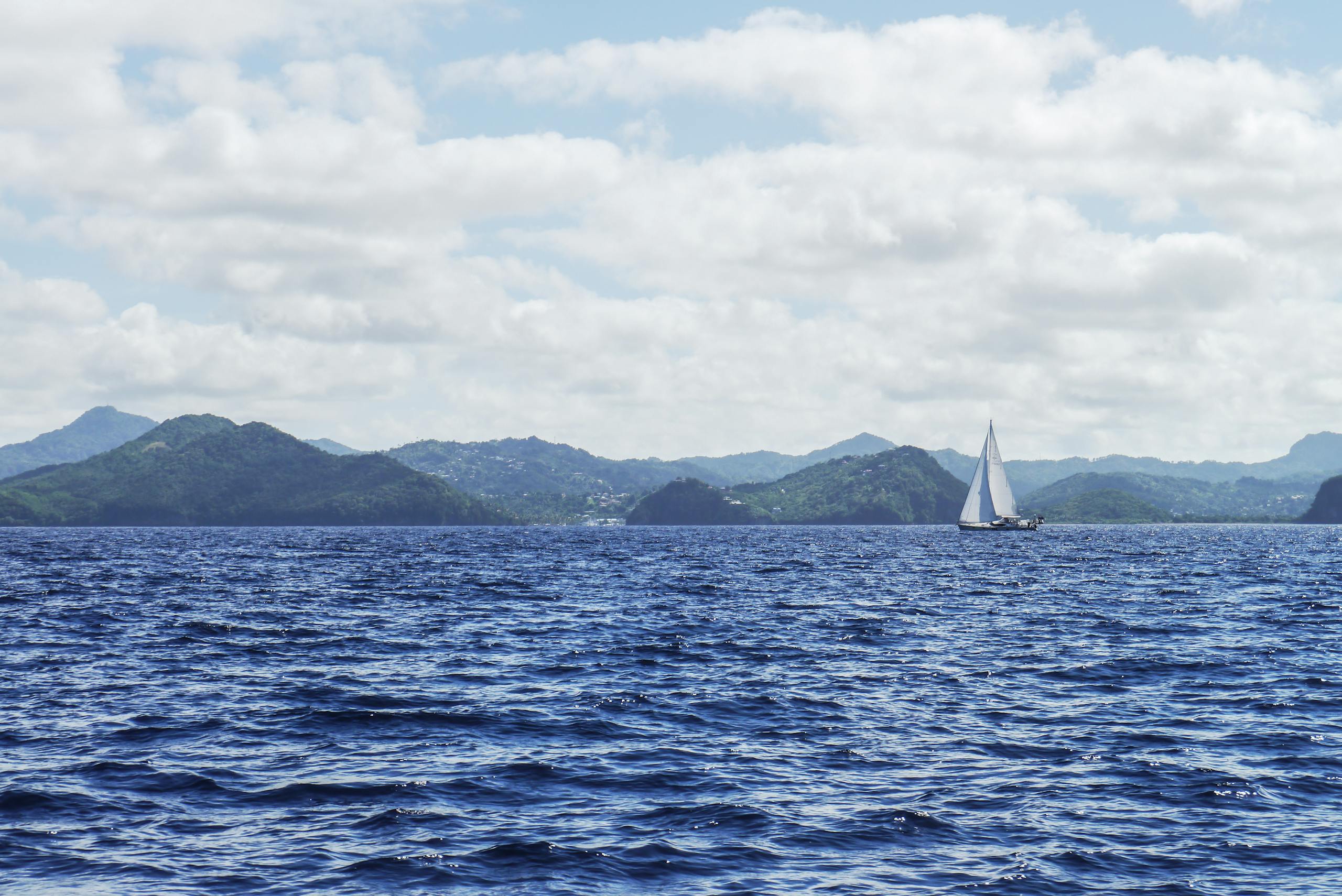 White Boat With Sail on Body of Water